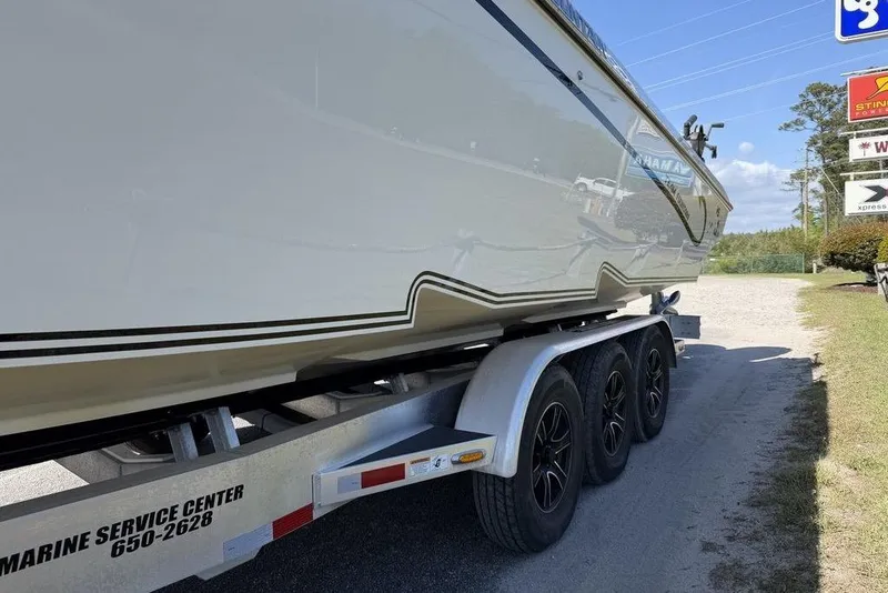 Slide: The Image of 2004 Fountain Bluewater 34 CC boat on a triple-axle trailer at a service center. - 68