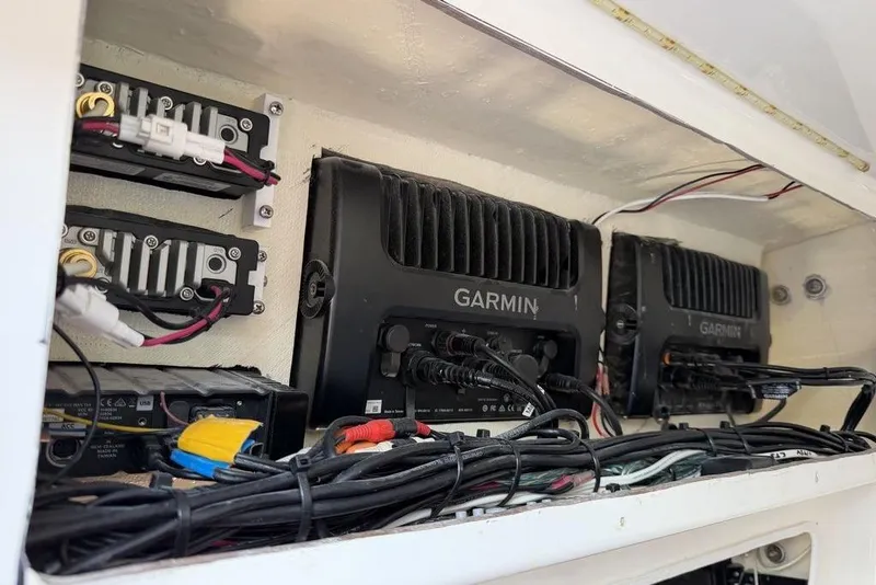 Slide: The Image of Electronics setup in 2004 Fountain Bluewater 34 CC boat featuring Garmin devices and wiring. - 69