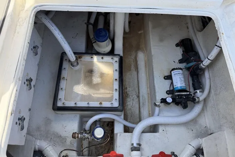 Slide: The Image of Bilge area of a 2004 Fountain Bluewater 34 CC boat with visible pumps and hoses. - 78