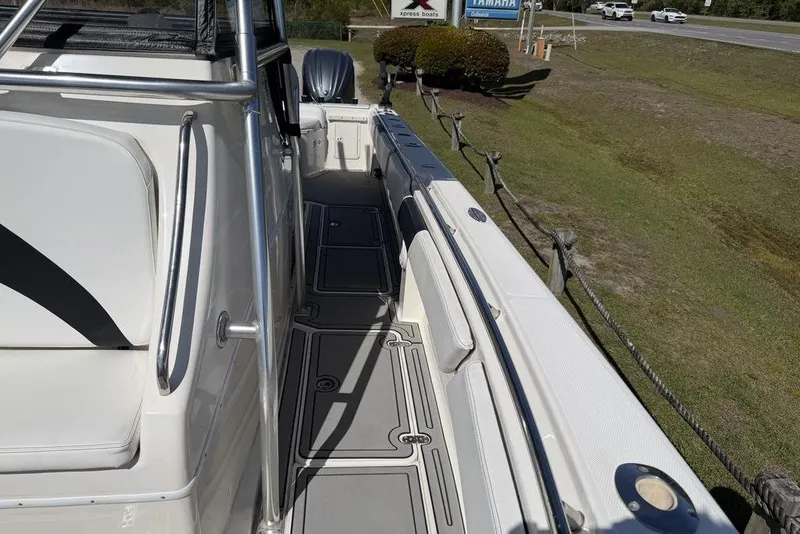Slide: The Image of 2004 Fountain Bluewater 34 CC boat deck with seating and railing, parked on grass. - 8