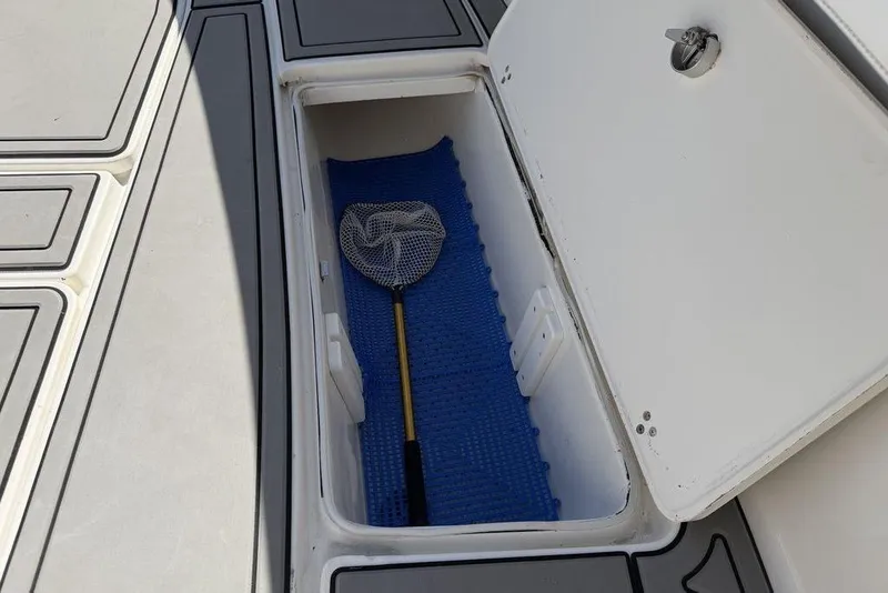 Slide: The Image of Open storage compartment on 2004 Fountain Bluewater 34 CC boat with fishing net inside. - 81