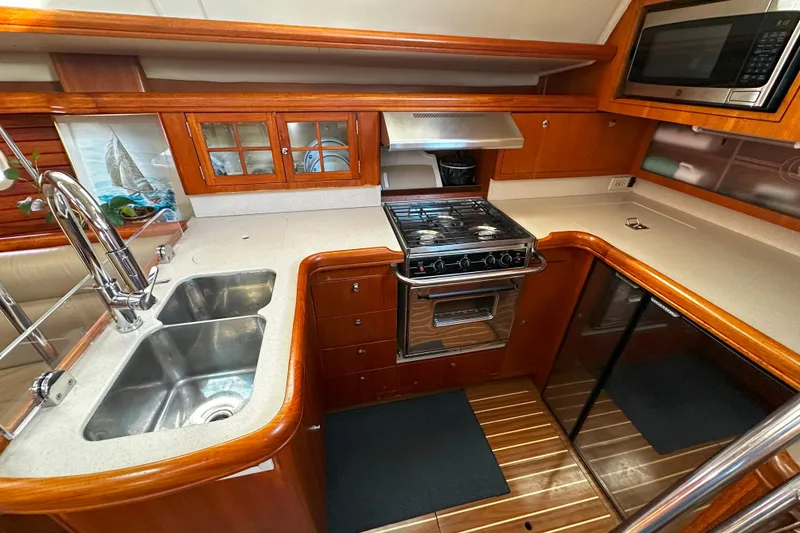 Slide: The Image of Luxurious 2006 Hunter 45 CC yacht kitchen with modern appliances and elegant wood finish. - 22