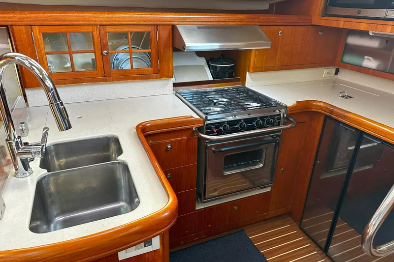 Slide: The Image of Luxurious 2006 Hunter 45 CC yacht kitchen with stove, sink, and wooden cabinetry. - 23