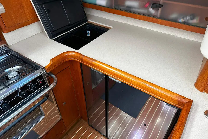 Slide: The Image of Hunter 45 CC 2006 yacht kitchen with stove, countertop, and wooden cabinetry. - 27
