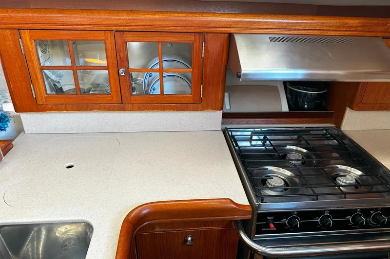 Slide: The Image of Hunter 45 CC 2006 yacht kitchen with stove, wooden cabinets, and countertop. - 29