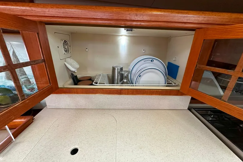Slide: The Image of Galley storage in 2006 Hunter 45 CC yacht with dishes and cleaning supplies. - 30