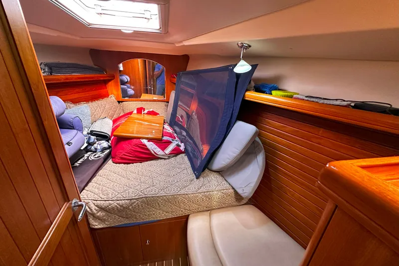 Slide: The Image of Cozy cabin interior of 2006 Hunter 45 CC sailboat with wooden paneling and bedding. - 32