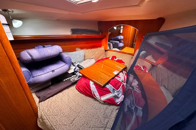 Slide: The Image of Cozy cabin interior of 2006 Hunter 45 CC sailboat with cushions and wooden table. - 34