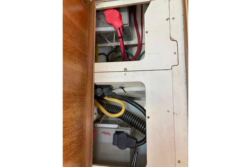 Slide: The Image of Electrical compartment of a 2006 Hunter 45 CC sailboat with visible wiring and components. - 69