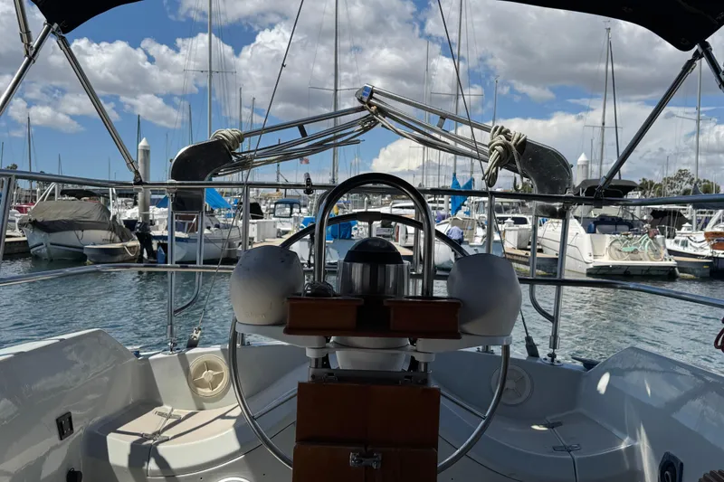 Slide: The Image of 1989 Ericson Sloop sailboat cockpit view in marina with cloudy sky. - 15
