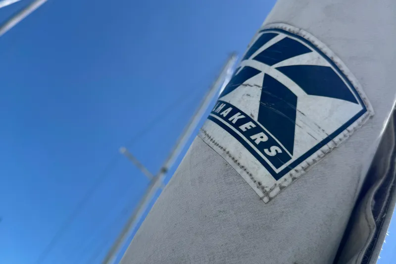 Slide: The Image of Close-up of a 1989 Ericson Sloop sail with a sailmaker's logo against a clear blue sky. - 16