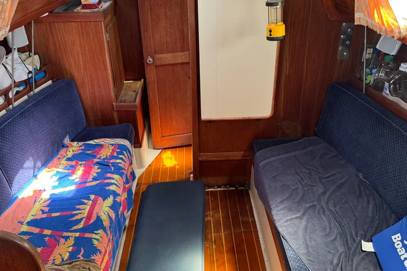 Slide: The Image of Interior of a 1989 Ericson Sloop sailboat with cozy seating and wooden finishes. - 22