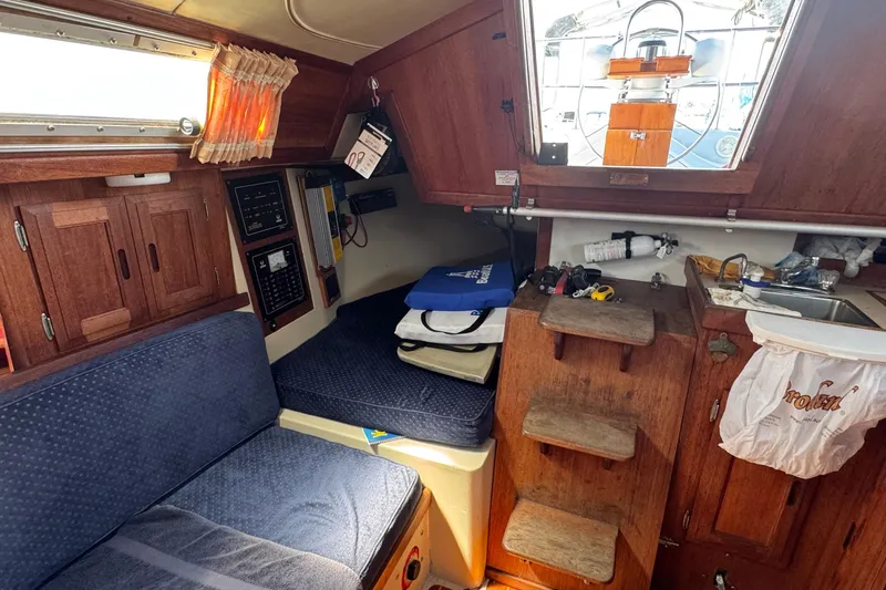 Slide: The Image of Interior of a 1989 Ericson Sloop sailboat with wooden cabinetry and seating. - 23