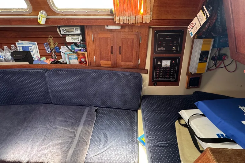 Slide: The Image of Interior of a 1989 Ericson Sloop sailboat with blue cushions and wooden cabinetry. - 27