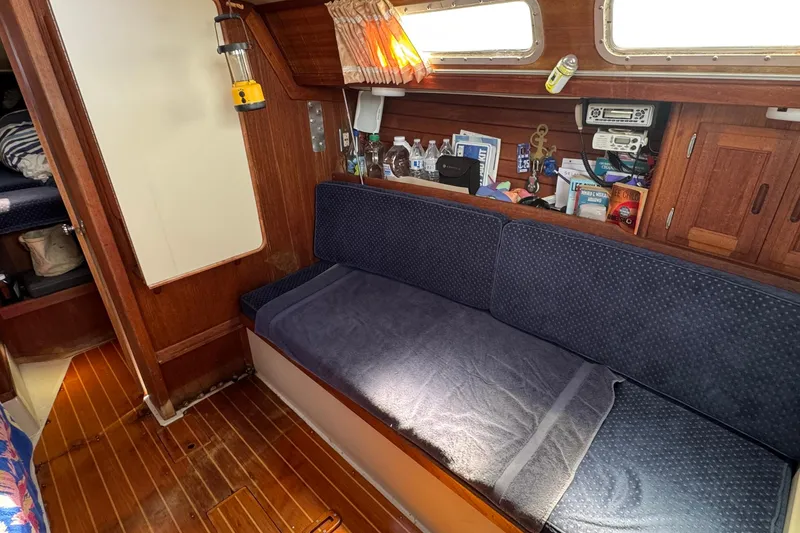 Slide: The Image of Interior of a 1989 Ericson Sloop sailboat with cozy seating and wooden accents. - 31