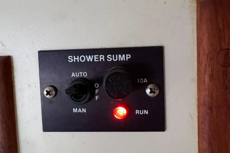 Slide: The Image of Control panel for shower sump on 1989 Ericson Sloop, featuring auto and manual settings. - 36