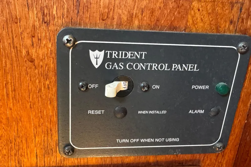 Slide: The Image of Trident gas control panel on 1989 Ericson Sloop, featuring power and alarm indicators. - 38