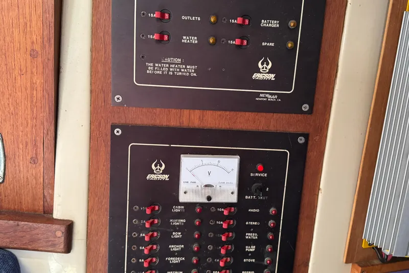 Slide: The Image of Electrical panel on a 1989 Ericson Sloop sailboat, featuring switches and a voltmeter. - 39