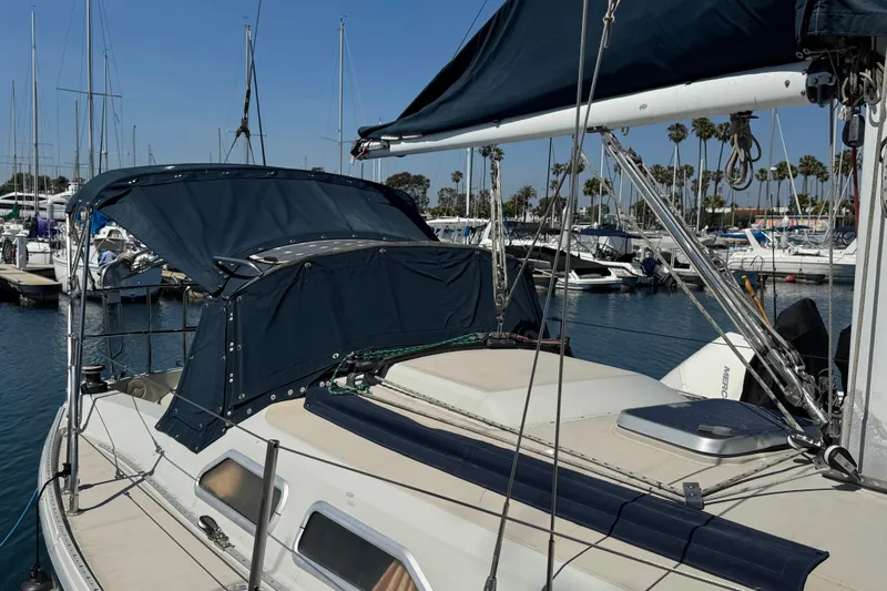 Slide: The Image of 1989 Ericson Sloop sailboat docked at marina with blue canopy and rigging. - 4