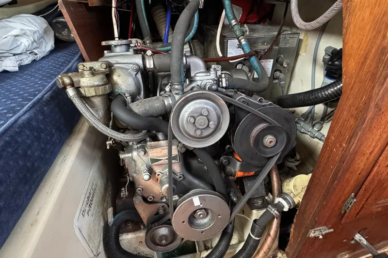 Slide: The Image of Engine compartment of a 1989 Ericson Sloop sailboat, showcasing mechanical components and hoses. - 41