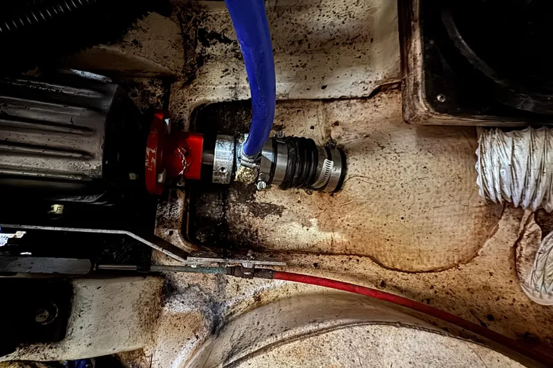 Slide: The Image of Engine compartment of a 1989 Ericson Sloop with visible hoses and fittings. - 43