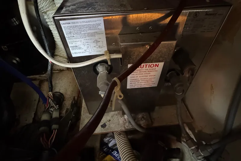 Slide: The Image of Electrical system inside 1989 Ericson Sloop, featuring wiring and caution labels. - 44