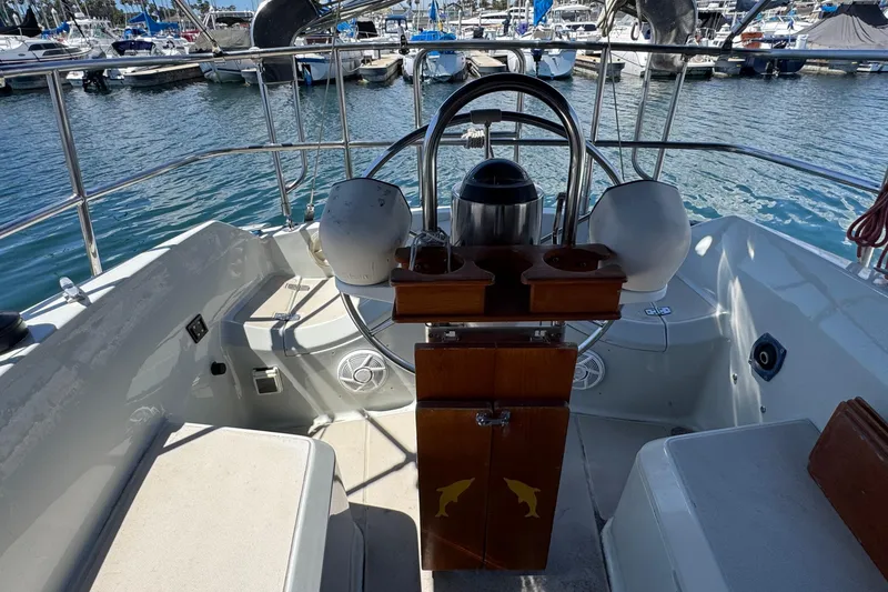 Slide: The Image of Cockpit of 1989 Ericson Sloop yacht with steering wheel and marina view. - 7