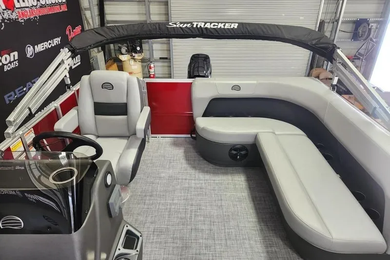 Slide: The Image of 2026 Sun Tracker Party Barge 16 DLX interior with gray seating and steering console. - 7