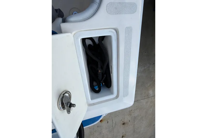 Slide: The Image of Storage compartment on a 2006 Concept 30 PF Open Fish boat, featuring a secure latch. - 18