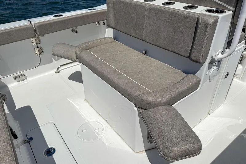 Slide: The Image of 2025 Sea Hunt Ultra 275 SE boat seating area with gray cushioned bench and cup holders. - 10