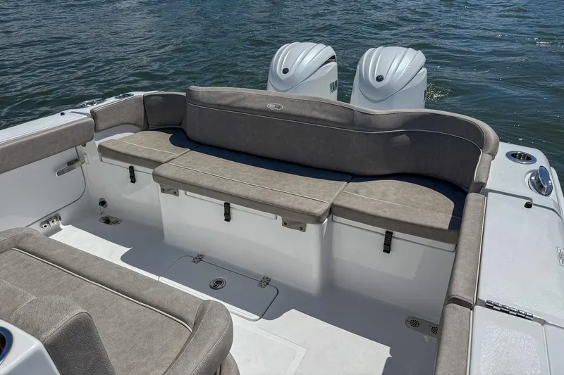 Slide: The Image of 2025 Sea Hunt Ultra 275 SE boat interior with cushioned seating and twin engines. - 11