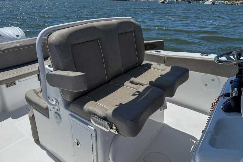 Slide: The Image of 2025 Sea Hunt Ultra 275 SE boat interior with cushioned seating and steering console. - 18