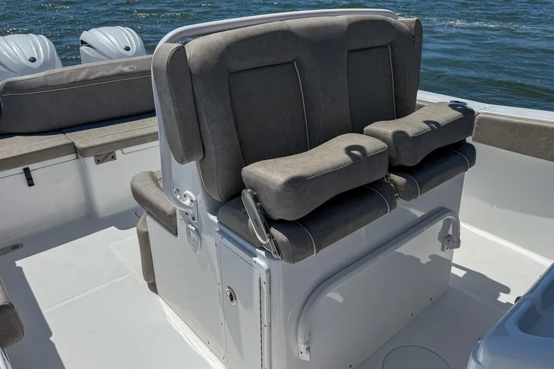 Slide: The Image of 2025 Sea Hunt Ultra 275 SE boat interior with cushioned seating and dual outboard motors. - 19