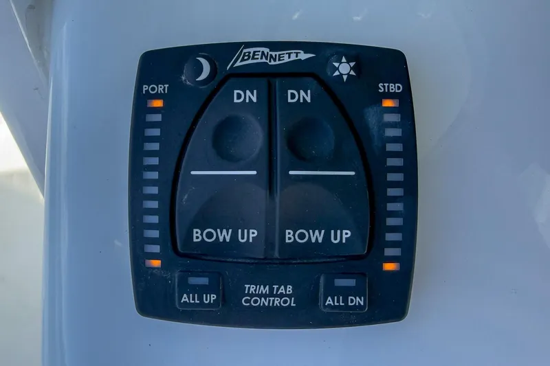 Slide: The Image of 2025 Sea Hunt Ultra 275 SE trim tab control panel with Bennett branding. - 26
