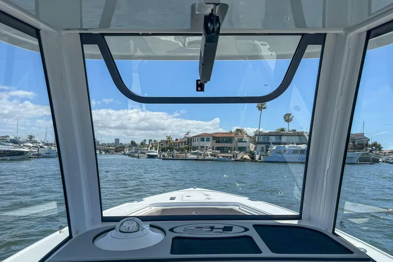 Slide: The Image of Interior view from a 2025 Sea Hunt Ultra 275 SE boat, overlooking a marina. - 27