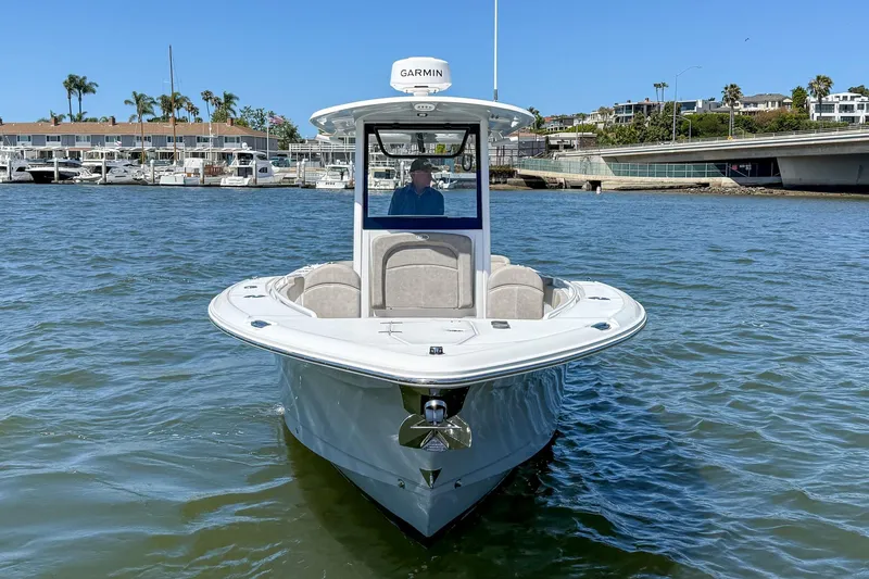 Slide: The Image of 2025 Sea Hunt Ultra 275 SE boat on water, with marina and buildings in background. - 3