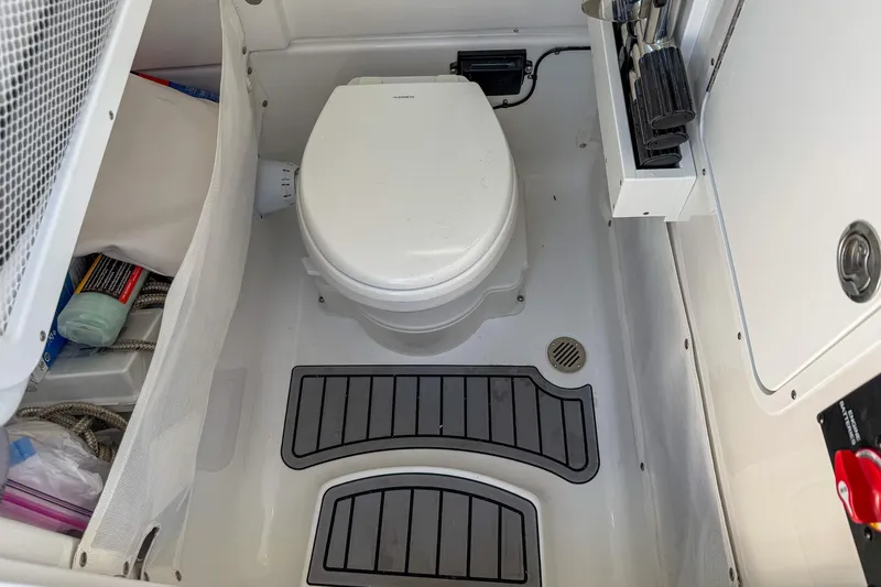 Slide: The Image of 2025 Sea Hunt Ultra 275 SE boat bathroom with toilet and storage compartments. - 31
