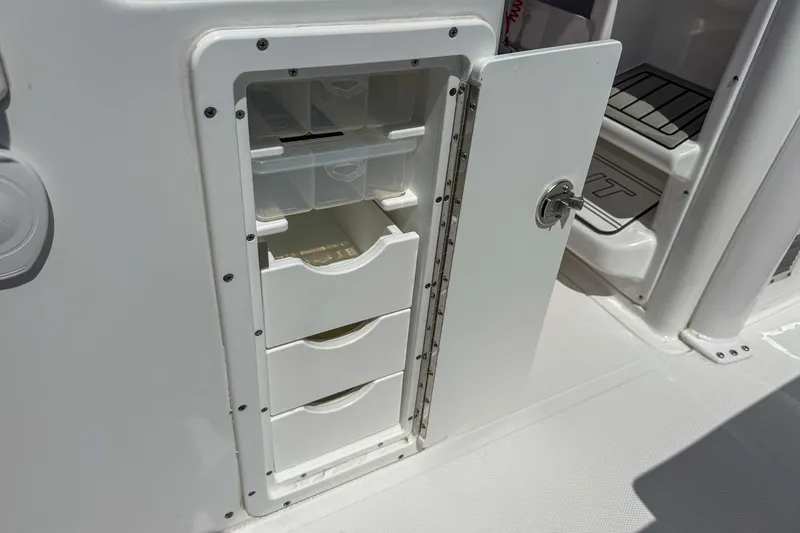 Slide: The Image of Storage compartment with drawers on a 2025 Sea Hunt Ultra 275 SE boat. - 46