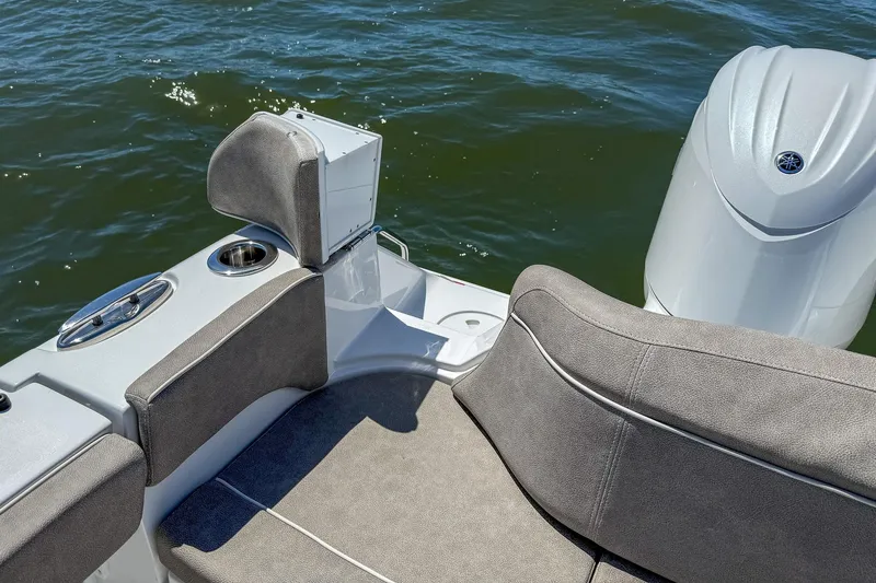 Slide: The Image of 2025 Sea Hunt Ultra 275 SE boat interior with cushioned seating and motor on water. - 48