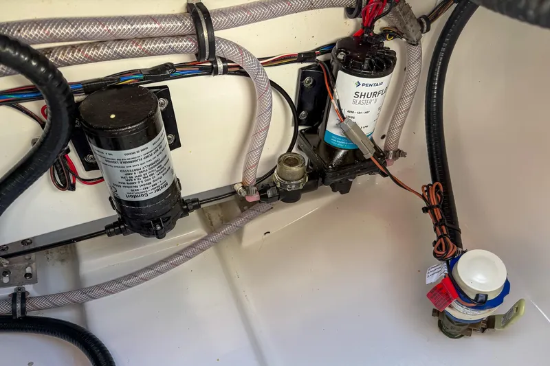 Slide: The Image of Electrical and plumbing components inside a 2025 Sea Hunt Ultra 275 SE boat. - 53