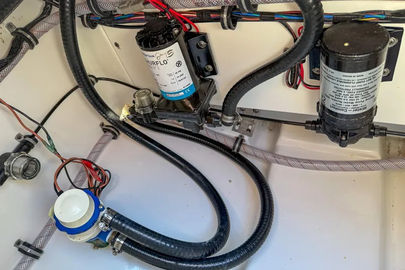 Slide: The Image of Electrical and plumbing components inside a 2025 Sea Hunt Ultra 275 SE boat. - 54