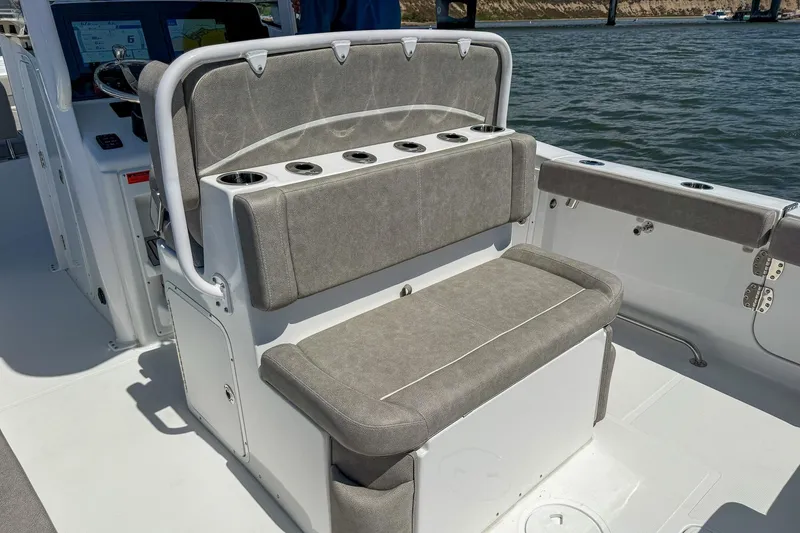 Slide: The Image of 2025 Sea Hunt Ultra 275 SE boat interior with cushioned seating and cup holders. - 9