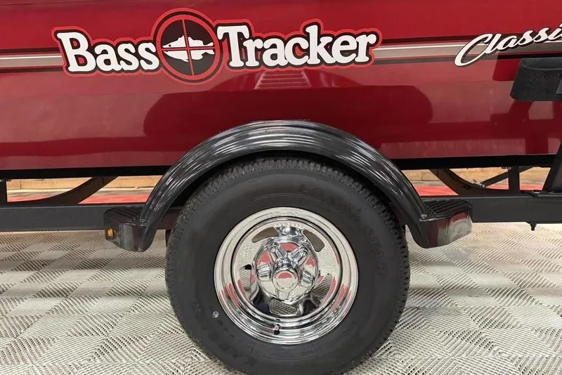 Slide: The Image of 2026 Bass Tracker Classic XL trailer with chrome wheel and red body design. - 11