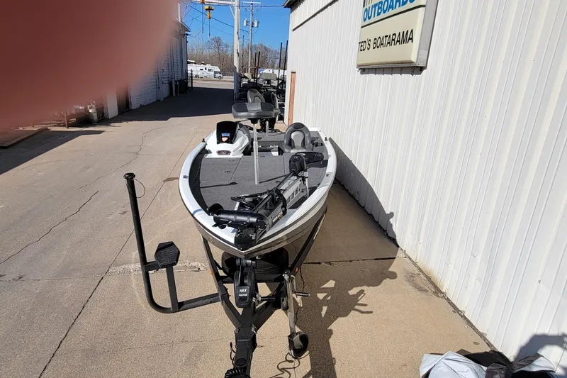 Slide: The Image of 2019 Vexus AVX1980 boat covered, parked at Ted's Boatarama, Mercury Outboards sign visible. - 2