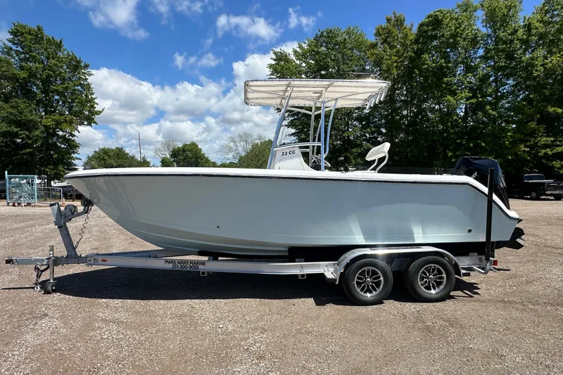 Slide: The Image of 2023 LFG 22 CC boat on trailer, parked outdoors under blue sky. - 2
