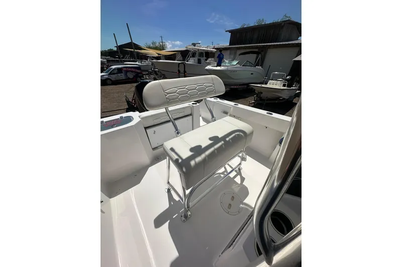 Slide: The Image of 2023 LFG 22 CC boat interior with white cushioned seating and storage compartments. - 22