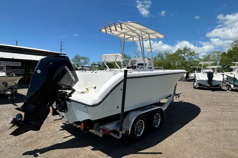 Slide: The Image of 2023 LFG 22 CC boat on trailer with outboard motor, parked outdoors. - 6