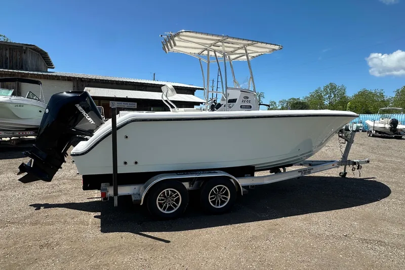 Slide: The Image of 2023 LFG 22 CC boat on trailer with Mercury outboard motor, parked outdoors. - 7
