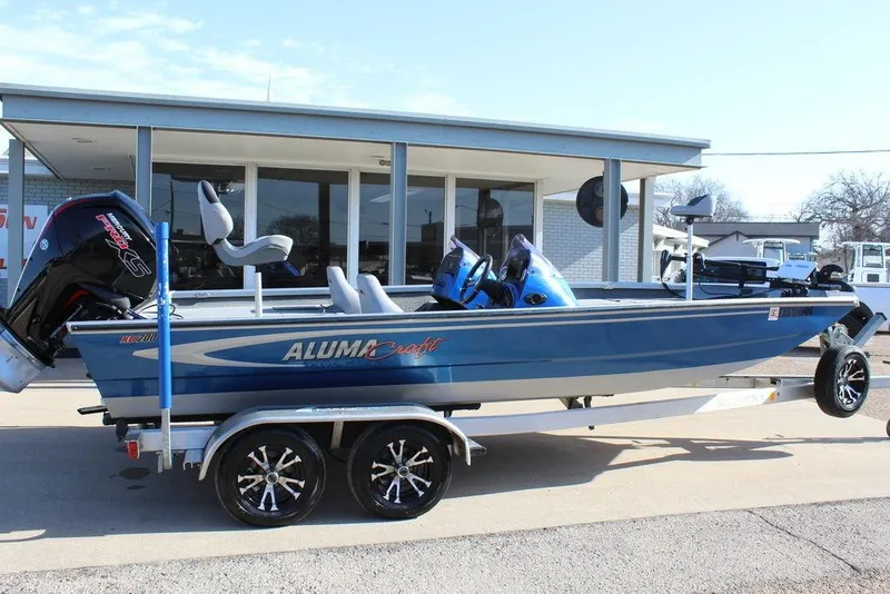 The Image of 2019 Alumacraft XB 200 boat on trailer, parked outside a building. - 0
