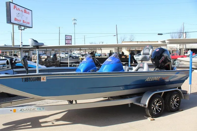 Slide: The Image of 2019 Alumacraft XB 200 boat on trailer at dealership, blue exterior, dual seats, outboard motor. - 10